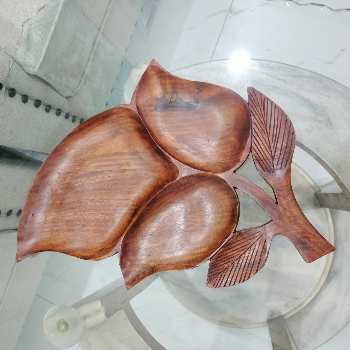 Wooden leaf-shaped spoons on a glass surface with a metallic background