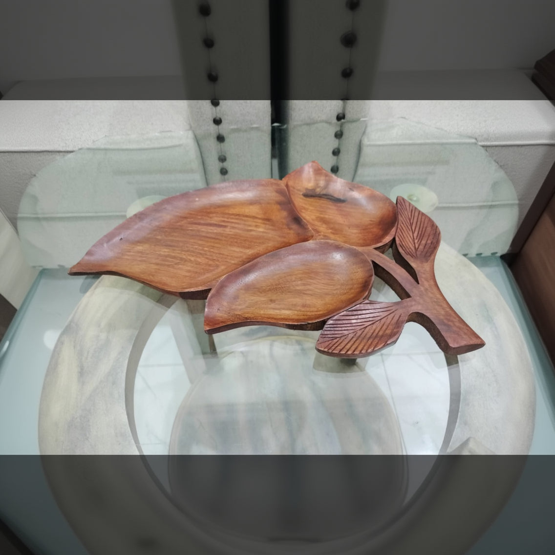 Wooden leaf-shaped trays on a glass surface