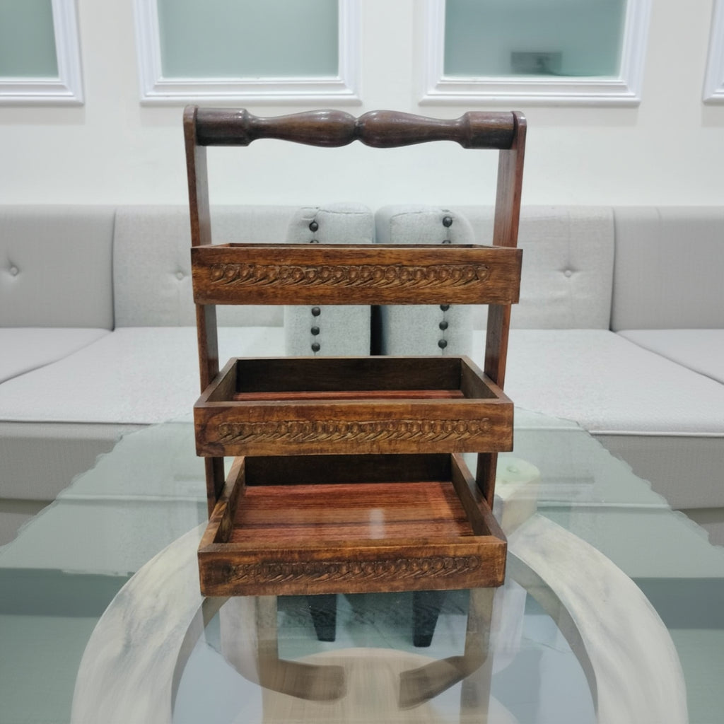 Wooden tiered stand with intricate carvings on a reflective surface.