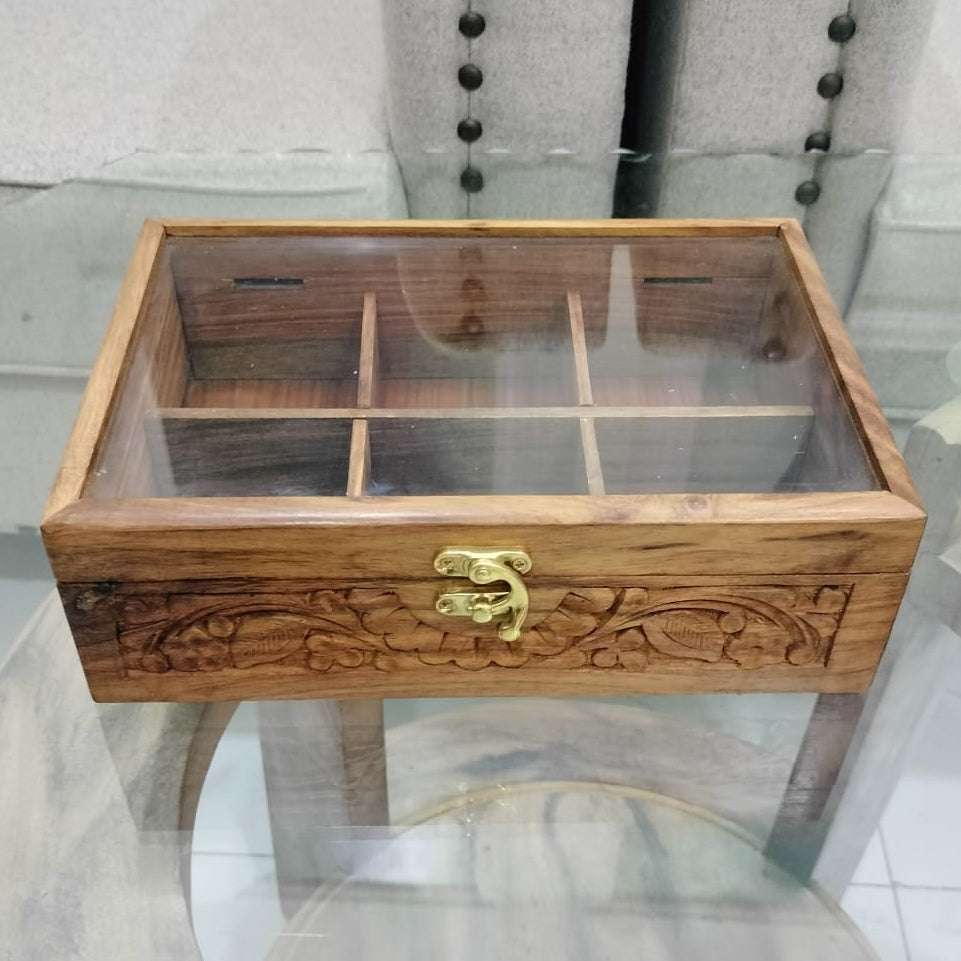 Wooden jewelry box with glass top on a round glass table