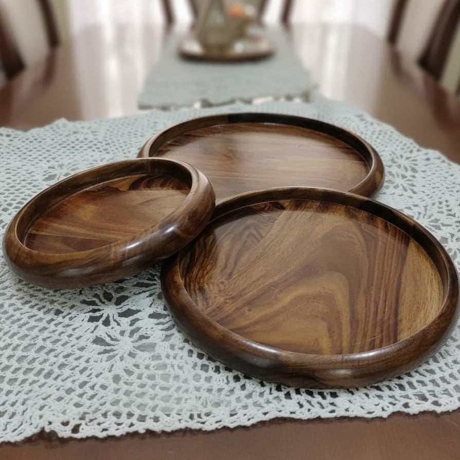 Three wooden trays on a lace tablecloth with a blurred background