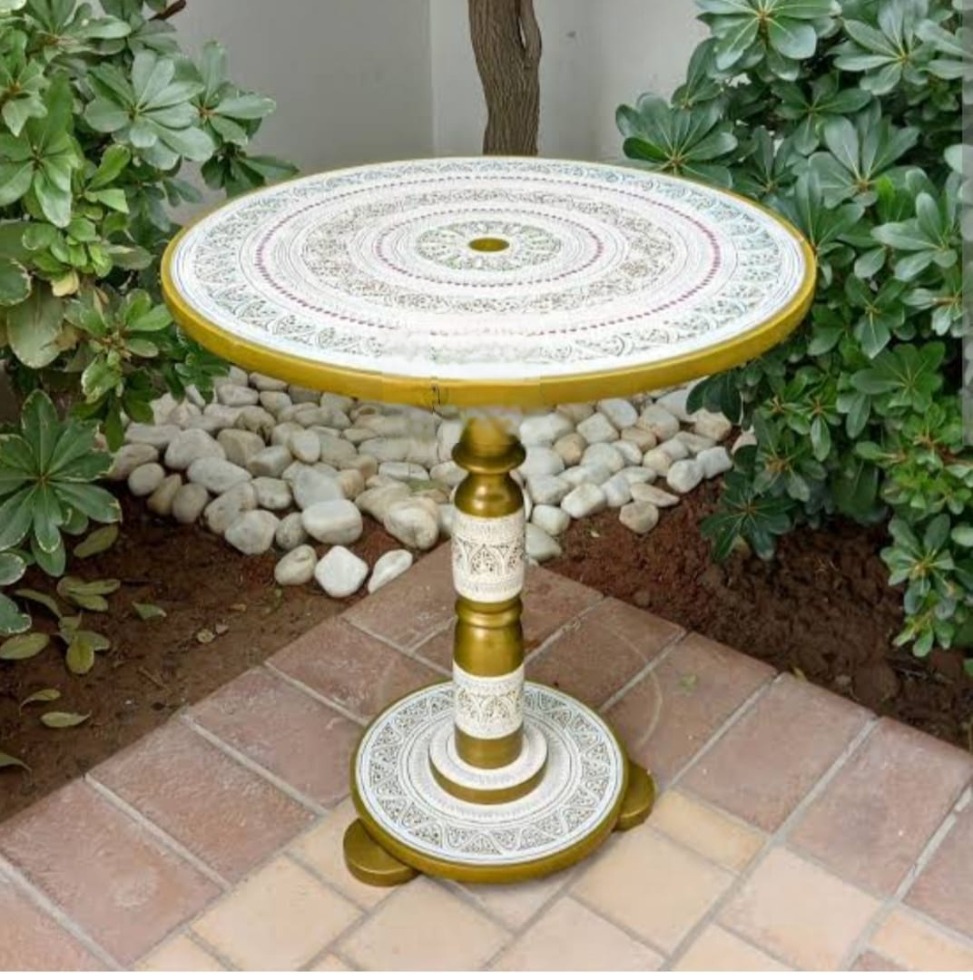 Decorative round table with intricate design in a garden setting
