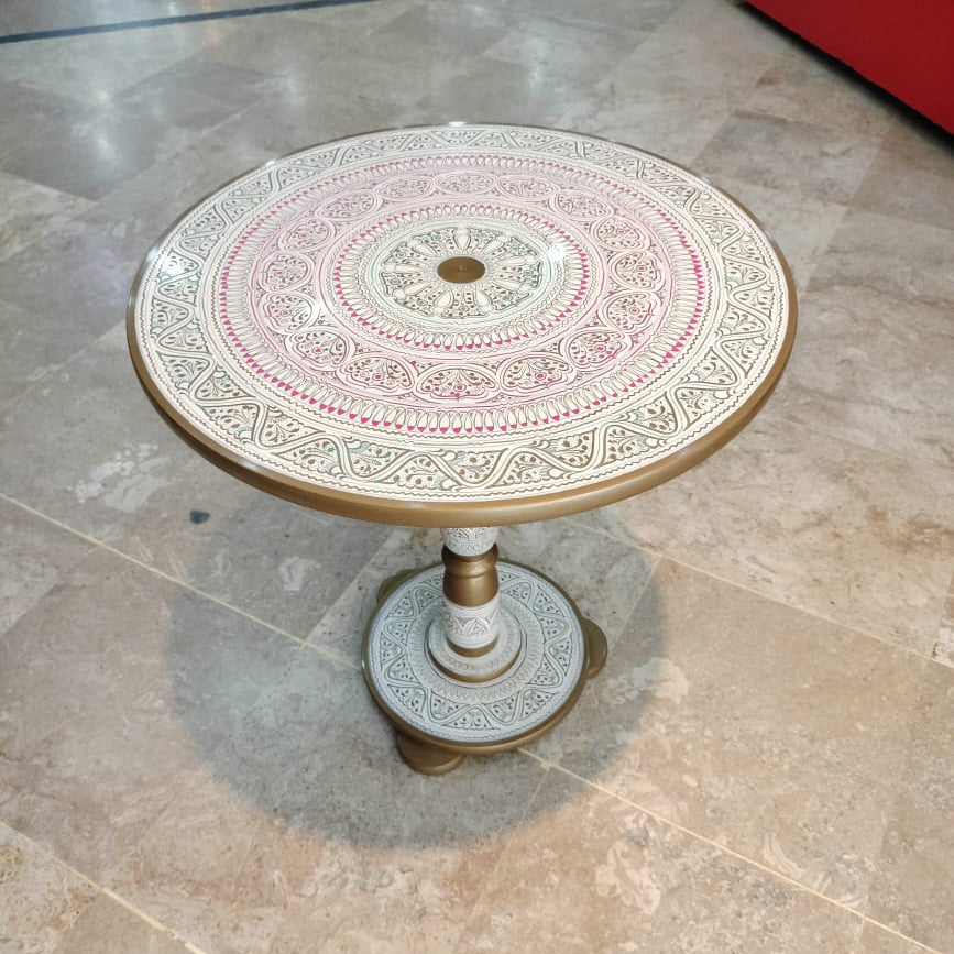 Decorative round table with intricate patterns on a tiled floor