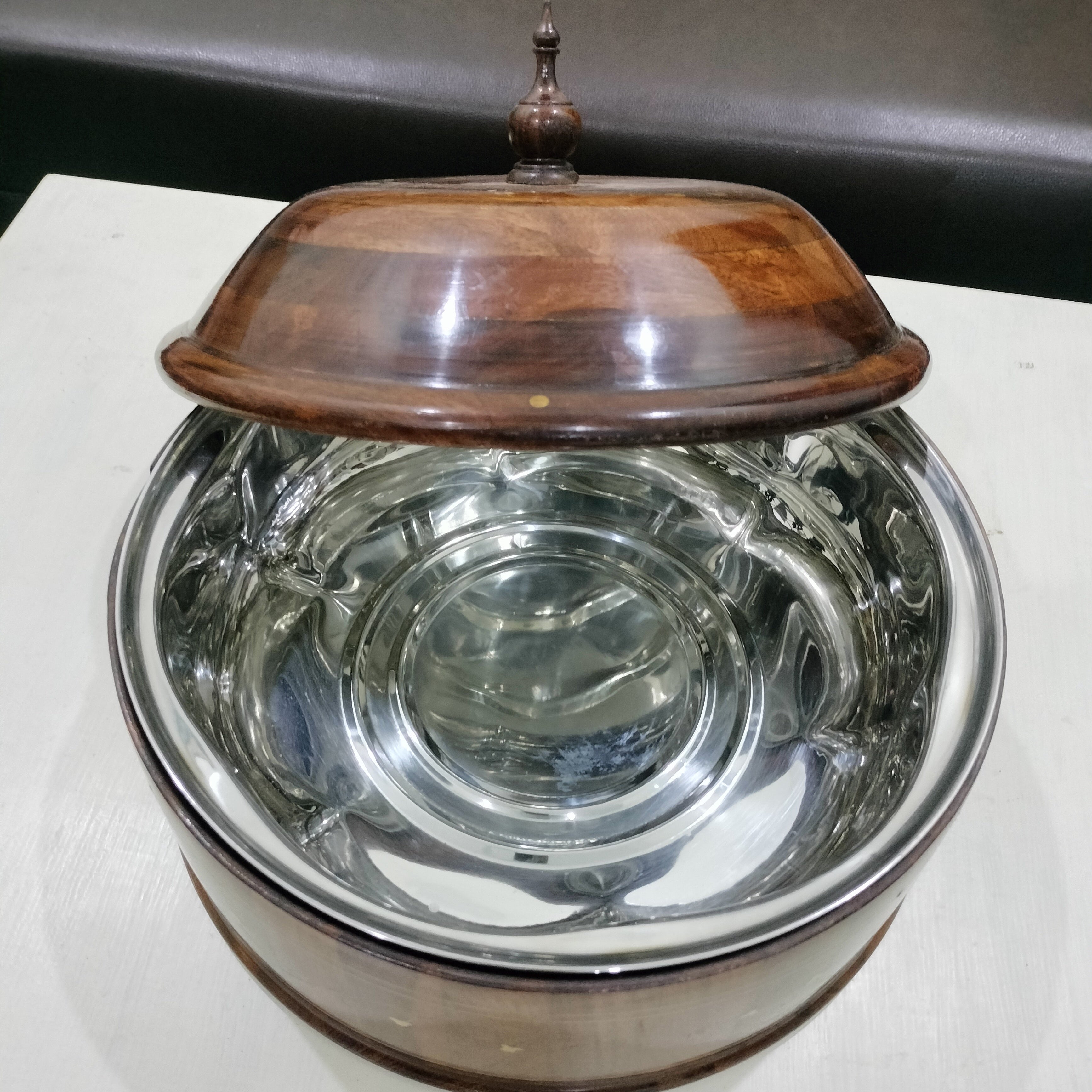 Clear glass container with wooden lid on a white surface