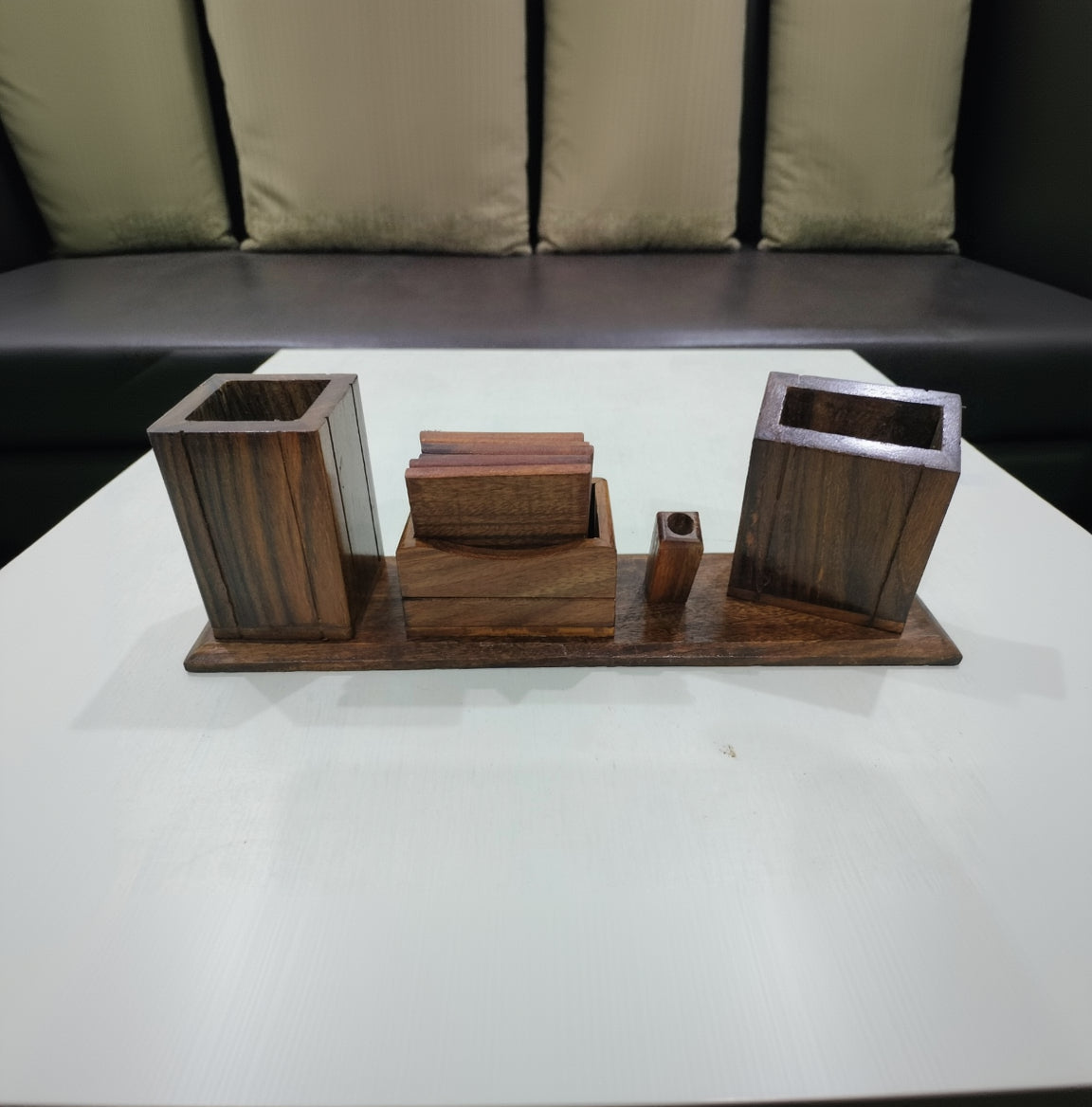 Wooden desk organizer with three cylindrical containers on a white surface.